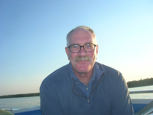 Headshot of man smiling at camera, on a boat